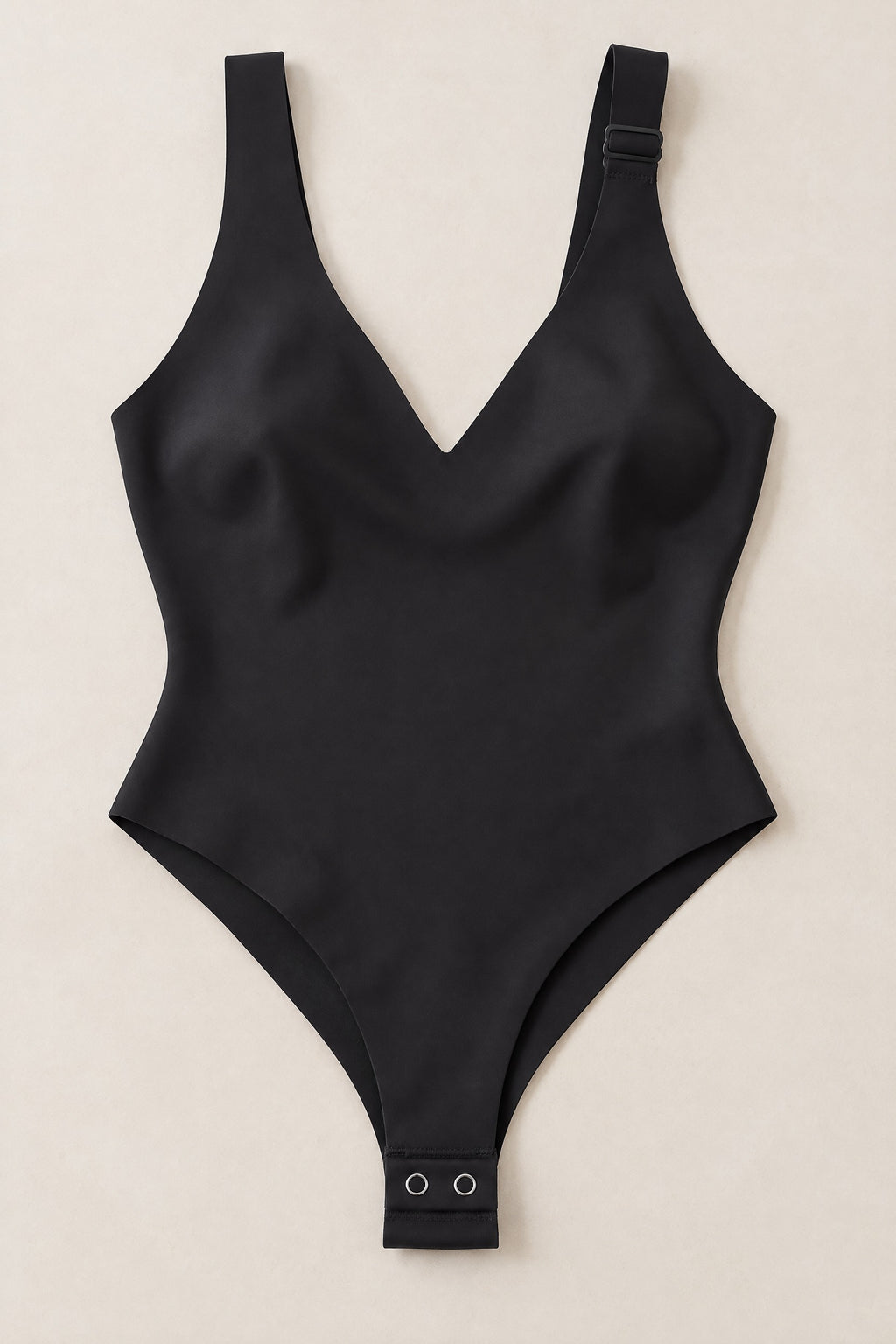 Plunge Thong Bodysuit in Black, laid flat with the snap gusset