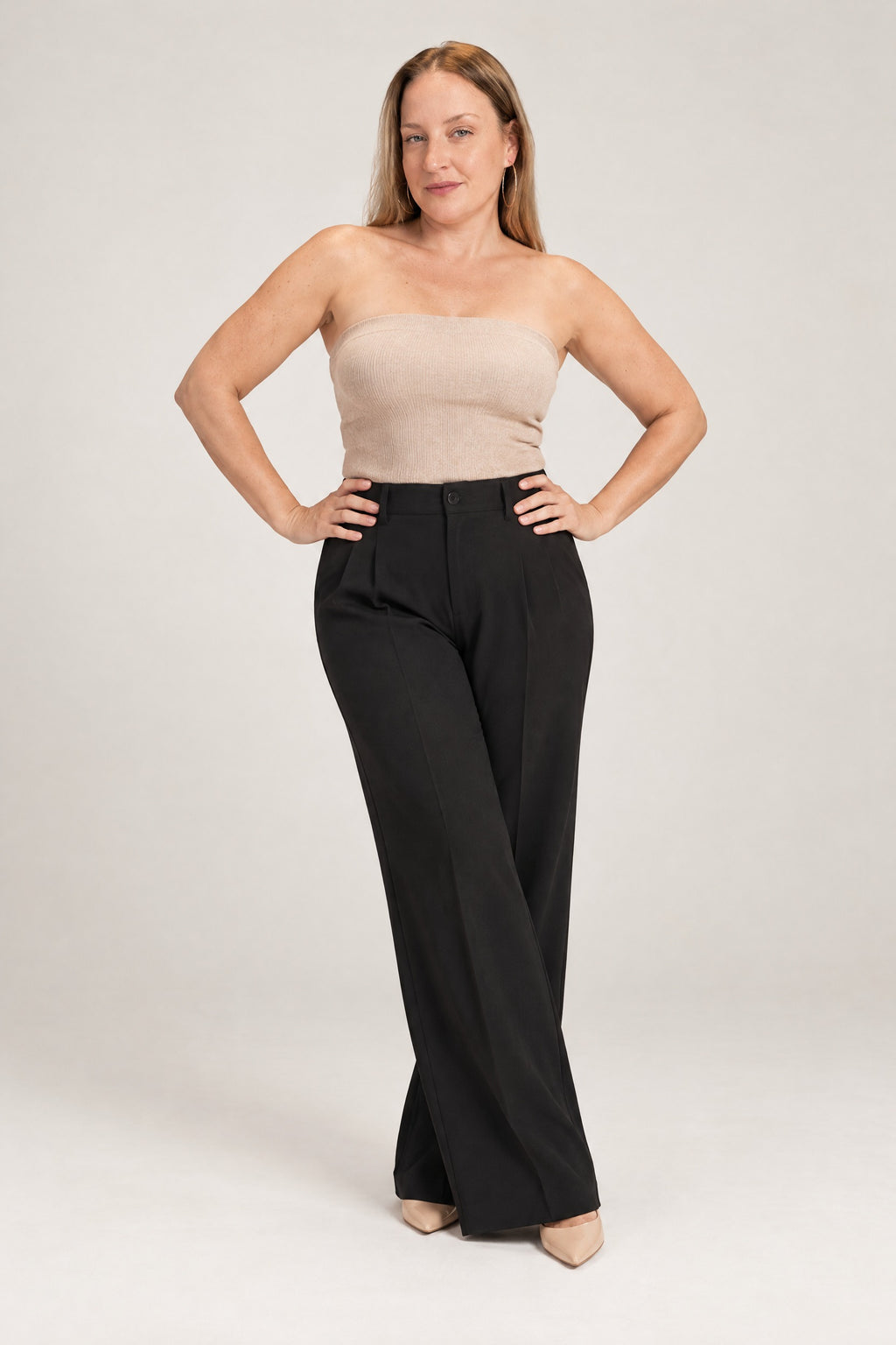 Woman in a strapless knit top and wide-leg trousers, front view